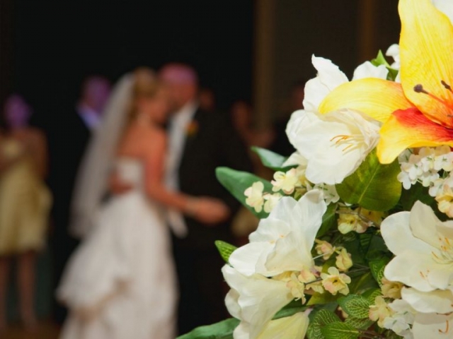Flowers in the foreground, Bride and Groom in the background out of focus